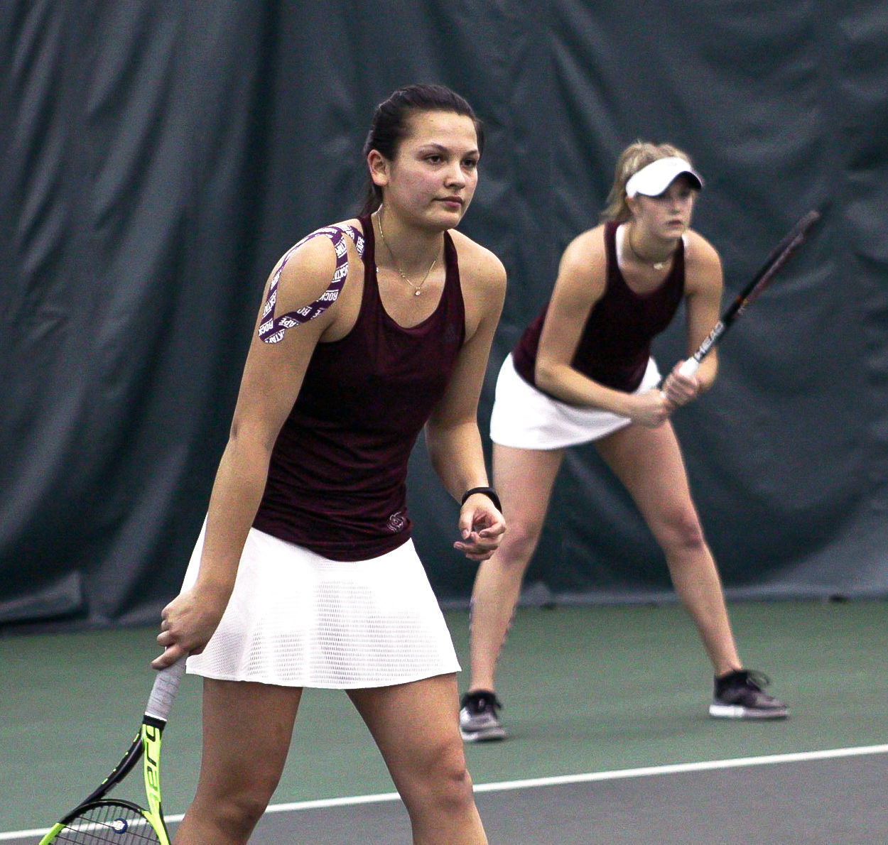 Anna Alons and Ellie Burger prepare to return their opponent's serve